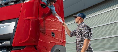 Semi Truck Driver Receiving Cargo Documentation While Staying in His Truck Cabin